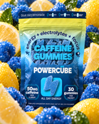 PowerCUBE Blue Razz Lemonade caffeine gummies pouch surrounded by blue raspberries and lemon slices.