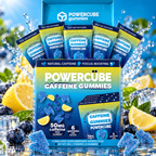 A retail display box of PowerCube Caffeine Gummies surrounded by lemons, blueberries, ice, and water splashes. The blue display box contains six individual packet packages of gummies, labeled 'blue razz lemonade' with 'POWERCUBE CAFFEINE GUMMIES' on the front.