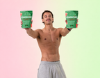 A shirtless male holding up a bag of sour watermelon creatine and electrolyte gummies