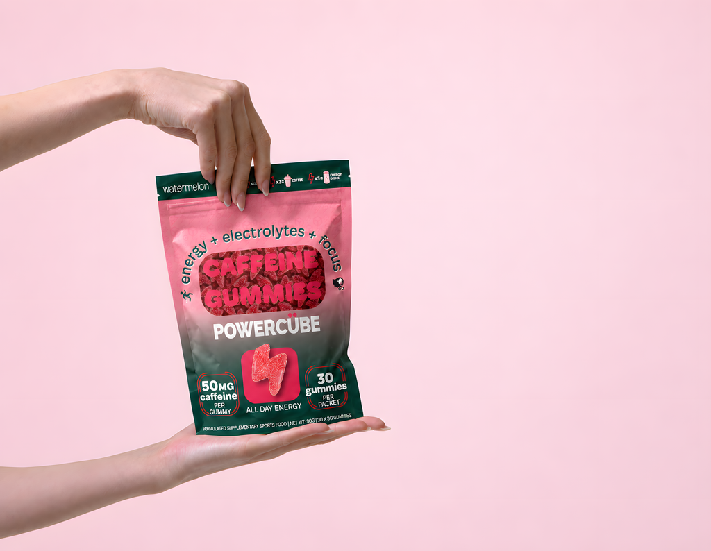 Hands holding an open PowerCUBE Watermelon caffeine gummies pouch and reaching inside.